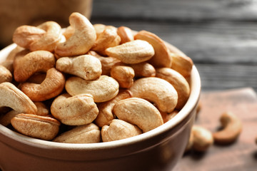 Bowl with cashew nuts on table, closeup