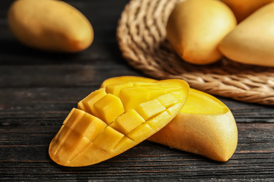 Ripe cut mango on wooden table, closeup
