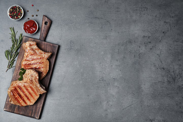 Flat lay composition with grilled meat on grey background. Space for text