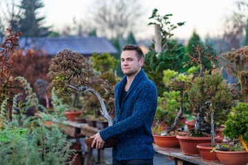 Man with asian bonsai tree.