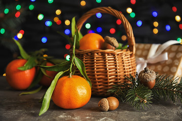 Fototapeta na wymiar Composition with ripe tangerines and blurred Christmas lights on background