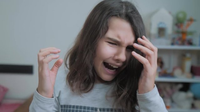 schoolgirl covering her face with her hands. emotion depression concept children. Shocked panic little girl screaming in despair and frustration. girl teenager screams opened her lifestyle mouth upset