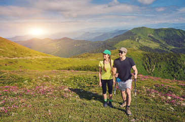 Obraz premium couple of hikers with backpacks enjoying panoramic view