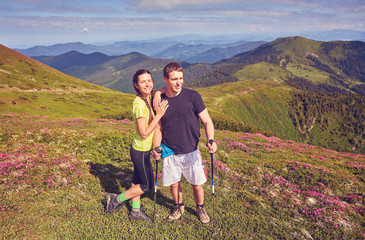 couple of hikers with backpacks enjoying panoramic view