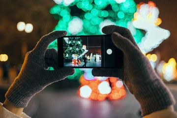 Woman's hands wearing warm gloves using mobile phone
