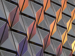 modern geometric triangular shiny silver steel cladding with highlights in gold and copper tones and perforated design