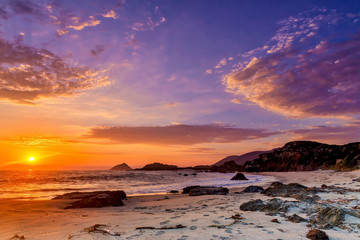 Setting Sun Over Rocky Coastline