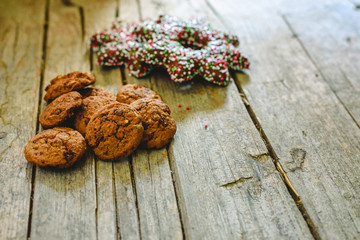 Small pile of chocolate cookies on aged wooden boards and chocolate star-shaped cookies.