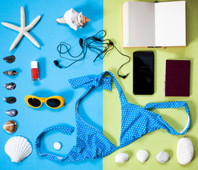 flat lay of beach holiday items: swimming suit,  sunglasses,  smartphone