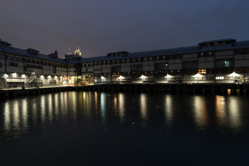 Fototapeta na wymiar waterfront warehouse at night with city in background