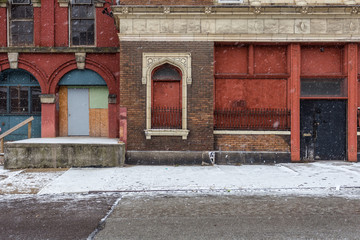 Vintage abandoned buildings on snow covered block in urban area