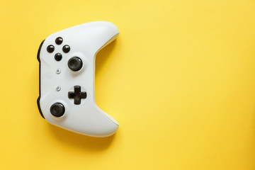 White joystick gamepad, game console on yellow colourful trendy modern fashion pin-up background. Computer gaming competition videogame control confrontation concept. Cyberspace symbol
