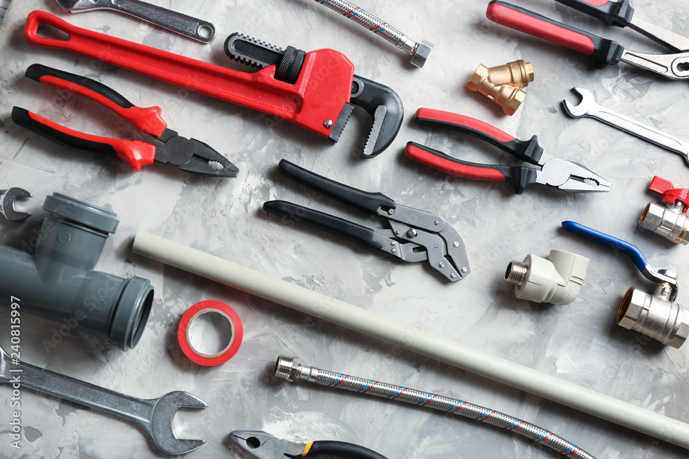 Poster Flat lay composition with plumber's tools on grey background