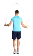 Sportive man training with jump rope on white background