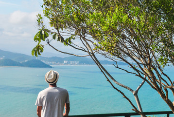 Turista olhando para o mar azul em Balneário Caboriú