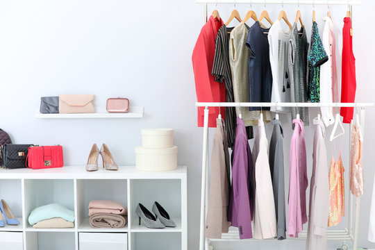 Racks with stylish clothes in light room