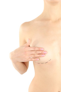 Young woman with marks on breast for cosmetic surgery operation against white background, closeup