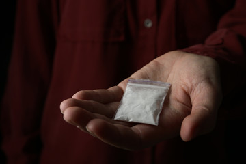 Drug dealer holding bag with cocaine, closeup