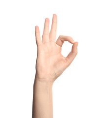 Young woman showing OK gesture on white background