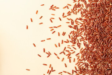Naklejka premium Brown rice on color background, top view with space for text
