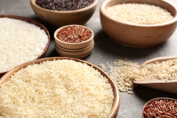 Brown and other types of rice on grey table