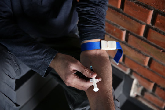 Male drug addict making injection, closeup of hands