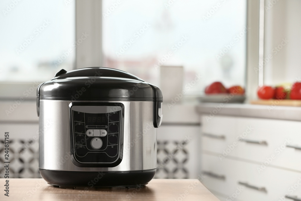 Poster Modern multi cooker on table in kitchen. Space for text