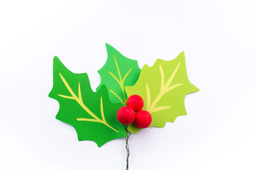 Flower holly made of paper crafts. Red berry from the ball.