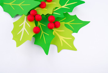 Flower holly made of paper crafts. Red berry from the ball.