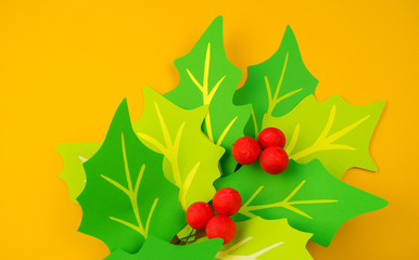 Flower holly made of paper crafts. Red berry from the ball.