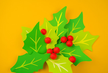Flower holly made of paper crafts. Red berry from the ball.