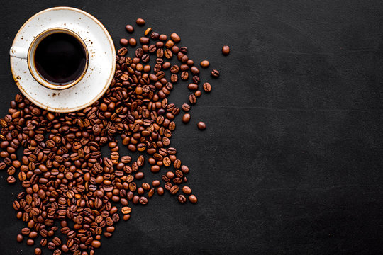 Coffee concept. Roasted beans and cup of espresso on black background top view copy space © 9dreamstudio