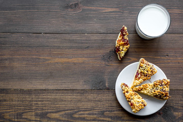 Children tradition evening dessert. Milk and homemade cookies on dark wooden background top view copy space