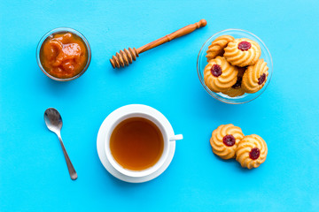 Dessert for evening tea. Cup of tea, fresh homemade cookies on blue background top view