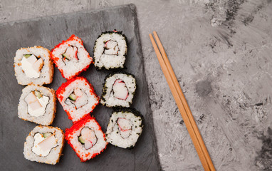 Japanese sushi rolls on stone background.
