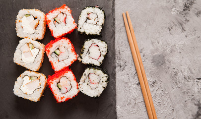 Japanese sushi rolls on stone background.
