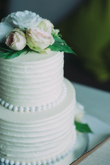 White wedding cake with flowers and blueberries