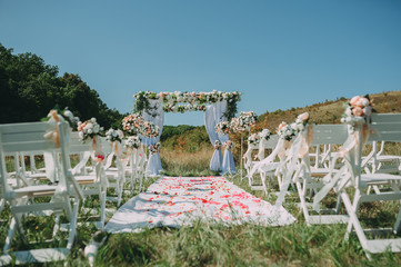 Wedding arch decorated with cloth and flowers outdoors. Beautiful wedding set up.Part of the festive decor, floral arrangement.