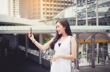Portrait beautiful asian woman selfie with mobilephone and walking in the city,Female confidence happy and smiling,Lifestyle concept