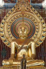 Golden buddha statue sitting in sanctuary at temple in Bangkok, Thailand.