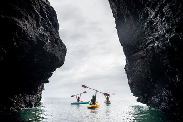 Happy kayakers sea rock walk kayaks