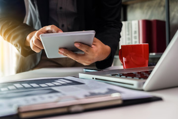 businessman hand using smart phone,tablet payments online shopping,omni channel,digital tablet docking keyboard computer at office in sun light.