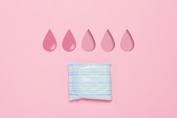 Feminine hygiene pad on a pink background. Concept of feminine hygiene during menstruation. Added drop mark, absorption level. two drops. Flat lay, top view