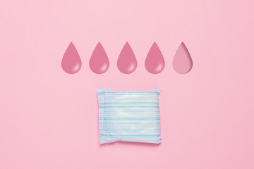 Feminine hygiene pad on a pink background. Concept of feminine hygiene during menstruation. Added drop mark, absorption level. four drops. Flat lay, top view