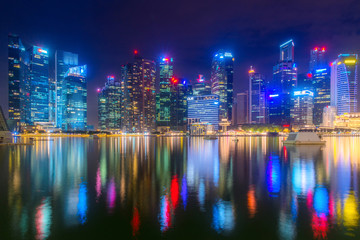 Reflection of skyscrapers around the Marina Bay at night in Singapore.