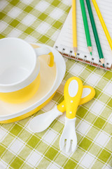 Set of yellow empty dishes for baby. Tableware for the first feeding, soft focus background