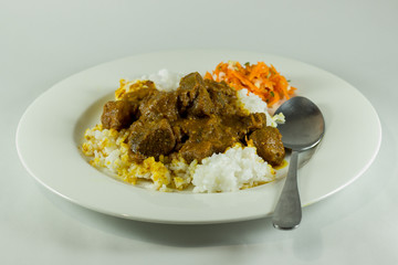 curry with rice and carrot salad on white plate