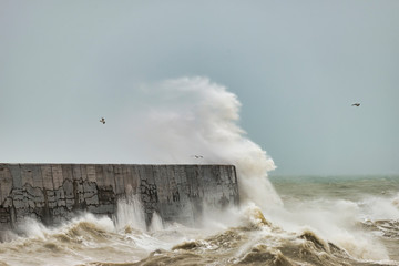 Stunning dangerous high waves crashing over harbor wall during windy Winter storm at Newhaven on...