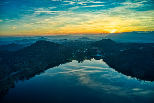 Aerial sunset over the lake in Italy during golden hour with mountains reflections