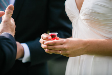 Obraz na płótnie Canvas bride taking communion cup during wedding ceremony